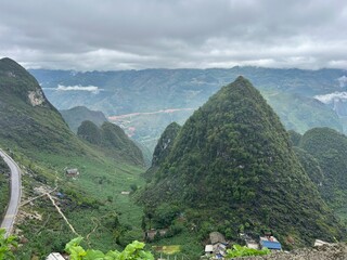 pointy mountains village below windy roads green