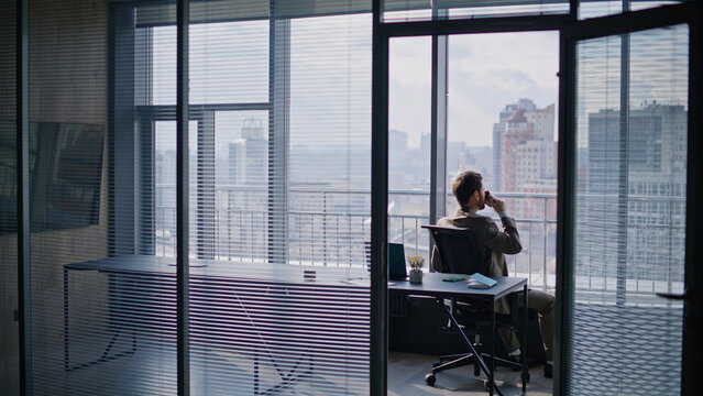 Successful businessman drinking coffee sitting window luxurious private office - Powered by Adobe