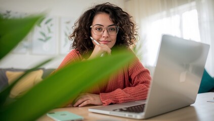 Laptop woman home office freelancer sitting at desk using computer in warm natural lighting