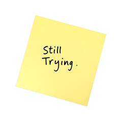 Motivational message on a pastel yellow sticky note Still Trying Simple and uplifting concept against a white background, isolated