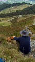 Man and Dog Relaxing on Mountain Overlooking Valley