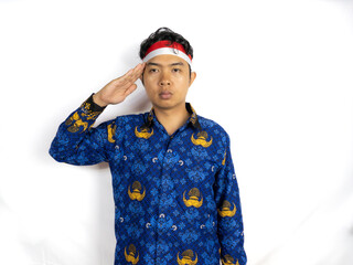 Fototapeta premium A young man Asian government worker with a happy successful expression, wearing flag headband and korpri uniform isolated by white background. Indonesia's independence day concept.