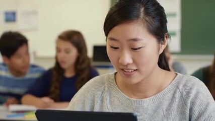 A student smiling while reading text on screen surrounded by fellow students and classroom tools melted softly into the background - Powered by Adobe