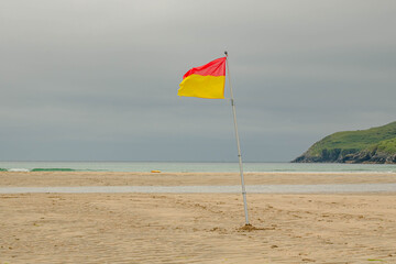 Red and yellow flag on the beach allowing swimming