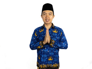 An Indonesian male civil servant wearing a blue Batik Korpri uniform poses with a respectful...