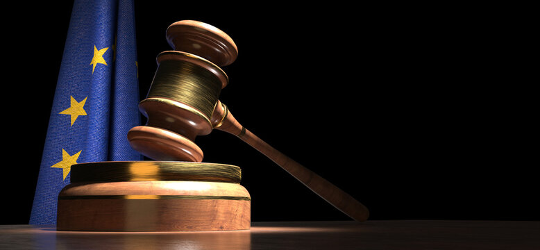 A wooden gavel rests on a wooden block in front of a blue flag with yellow stars, depicting the European Union.