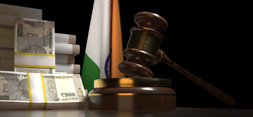 A wooden gavel and a stack of Indian rupee banknotes rest on a table in front of the Indian national flag.