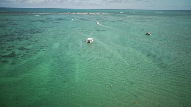Aerial drone view of Cabedelo coastline with turquoise ocean and boats sailing, Para&iacute;ba, Brazil