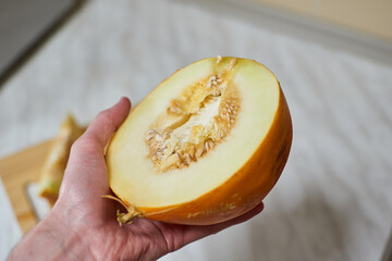 Hand-Cutting Ripe Melon on Wooden Cutting Board