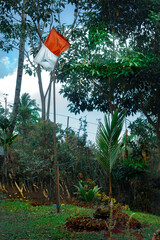 Outdoor shot of Indonesian flag amidst lush greenery, representing the country's spirit