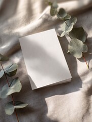 Minimalist workspace setup, blank notebook resting on soft fabric with greenery, ideal for journaling or creative planning.
