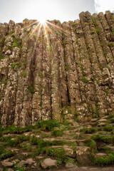 Hexagonal basalt columns seen from below with sunburst sky a dramatic natural formation in Northern Ireland geology and travel concept
