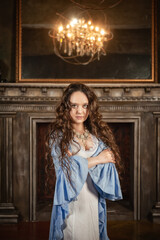 Beautiful sensual woman wears vintage underwear stands in the medieval room of the old castle with...