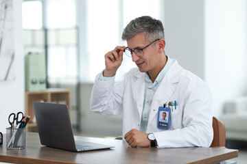 Telemedicine. Doctor having video call with patient via laptop indoors