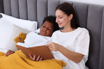 Mother reading fairy tale to her son at home
