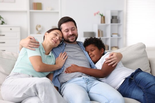 Adoption. Happy parents and their son at home