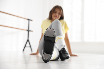 Teenage girl in tap shoes indoors, selective focus