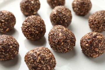 Tasty chocolate candies with nuts on white table, closeup