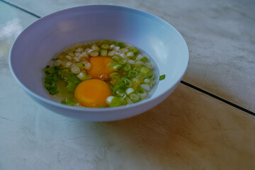 Cooking preparation, Process making an omelette. Mix two raw eggs with the leeks in a bowl. Breakfast menu. Copy space for text.