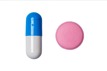 Photo of a blue and white pill with a pink tablet on the right side isolated on a transparent background top view Flat lay Studio lighting
