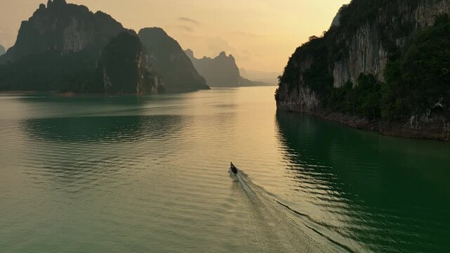 Aerial view tracking boat in on the lake of Khao Sok national park
