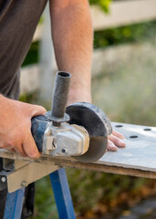 Mann schleift mit einem Winkelschleifer eine Fliese