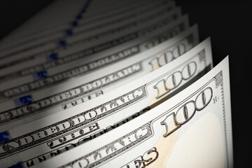 Spot Lit Abstract CLose-up Angle of U.S. 100 Dollar Bills Isolated on a Black Background.