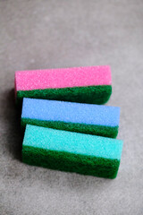 Multicolored sponges for dishwashing close-up isolated on gray