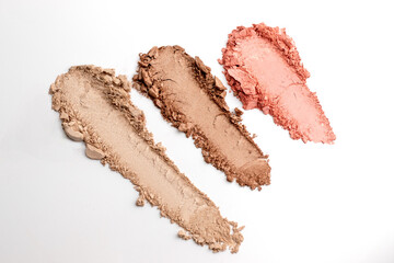 hree textures of bronzer, blush and highlighter on white background