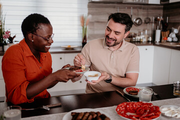 Friends enjoy a cozy meal together in a modern kitchen while sharing delicious dishes and laughter around the table