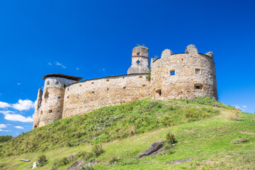 Obraz premium Zborov Castle near Bardejov town in North-Eastern Slovakia, Europe. Historic stone castle on grassy hill under a vibrant blue sky, showcasing architectural ruins and natural beauty.