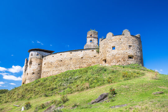 Zborov Castle near Bardejov town in North-Eastern Slovakia, Europe. Historic stone castle on grassy hill under a vibrant blue sky, showcasing architectural ruins and natural beauty.