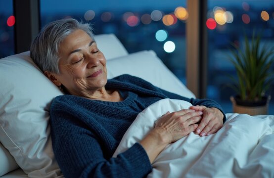 A senior woman peacefully sleeping in bed at night with city lights visible through the window - Powered by Adobe