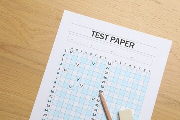 Answer sheet, eraser and pencil on wooden table, flat lay. Student passing exam