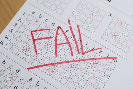 Answer sheet with word Fail on table, closeup. Student passing exam