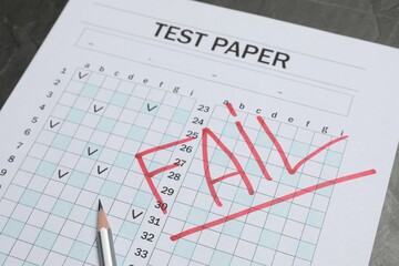 Answer sheet with word Fail and pencil on gray table, closeup. Student passing exam