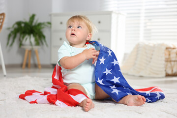 Cute little child with flag of USA on floor at home