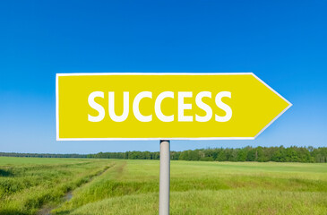 Success symbol. Concept word Success on beautiful yellow road sign. Beautiful blue sky green grass...