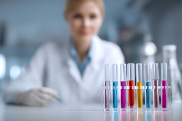 A scientist in a lab working with colorful test tubes, highlighting the importance of research and experimentation in the scientific process.