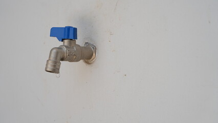 A drop of water drips from a leaky faucet. Tap and water drops