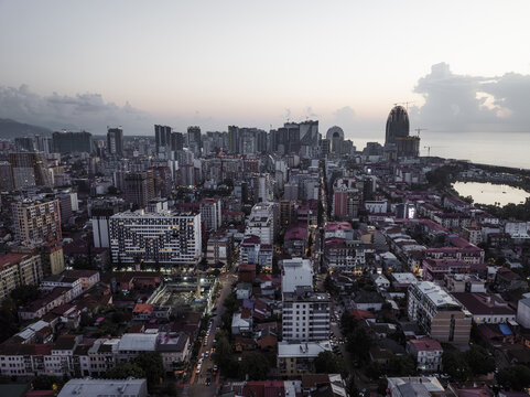 Aerial view of the city's skyline where modern buildings meet the sea under a soft sky, revealing the diverse architecture of Batumi, Adjara, Georgia.