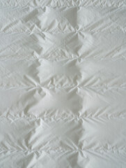 Obraz premium Close up of a white quilted fabric with diamond pattern and soft shadows creating a textured surface
