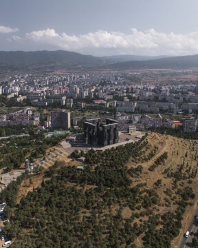 Aerial view of the imposing Chronicle of Georgia monument rises starkly against the sprawling cityscape, a testament to history etched in stone, Tbilisi, Tbilisi, Georgia.