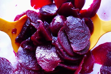 Beetroot in a bowl mixed with plastic spoons food background 