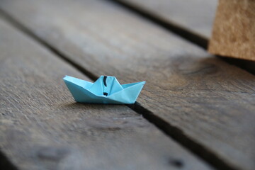 Paper boat on vintage wooden background