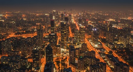 Aerial view of a brightly illuminated city skyline at night, showcasing numerous skyscrapers and buildings with warm, glowing lights.