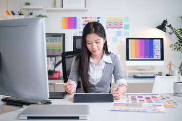 Young designer reviewing color palettes with a tablet in a bright and modern office.