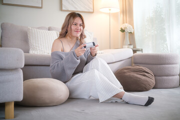 Happy woman holding game controller, enjoying entertainment and fun at home.