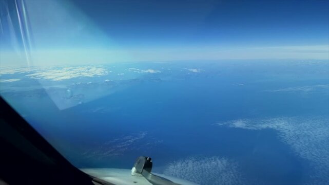 Time-lapse captured from the cockpit of a commercial airliner as the sun rises over the horizon at cruise altitude. The deep blue atmosphere gradually transitions to warm morning light, offering a dra