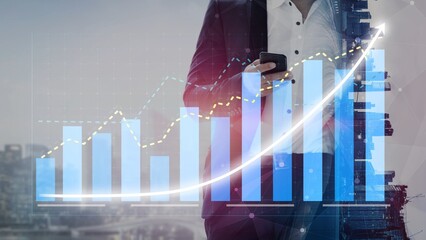 A businessman in a suit uses a smartphone while analyzing financial graphs and data in an urban setting, showcasing modern business trends and analytics. Copula